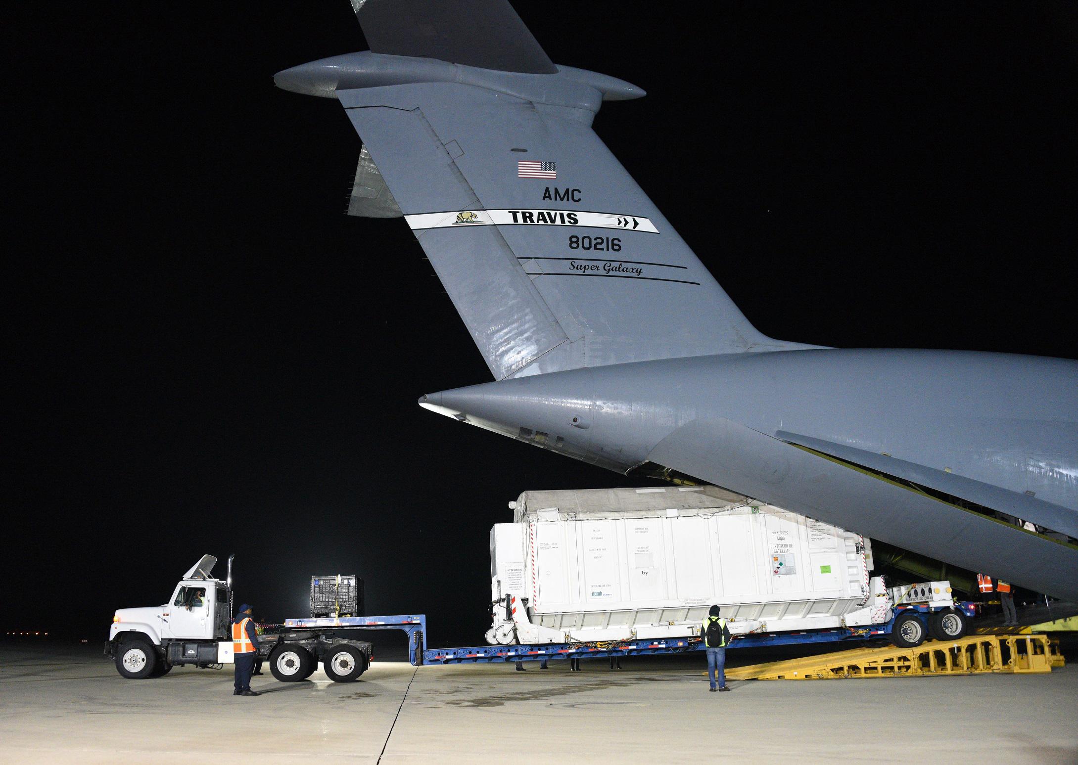 A photo of a container holding SWOT being offloaded at Vandenberg Space Force Base.
